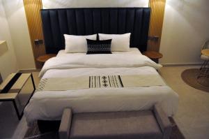 um quarto com uma cama grande e uma cabeceira preta em مساكن الدار 10 em Abha
