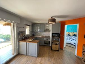 a kitchen with orange walls and a counter top at Le rayon vert in Six-Fours-les-Plages