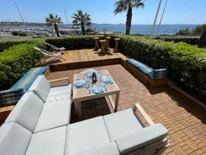 eine Terrasse mit weißen Sofas sowie einem Tisch und Stühlen in der Unterkunft Le rayon vert in Six-Fours-les-Plages