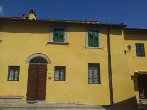 une maison jaune avec volets verts dans l'établissement Agriturismo Frigionaia, à Carmignano