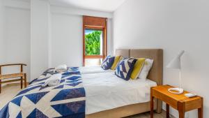 a bedroom with a bed and a table and a window at Casa Meri in Alvor