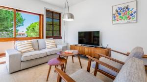 a living room with a couch and a tv at Casa Meri in Alvor