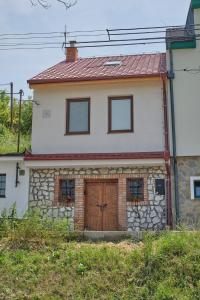 a stone house with a wooden door and windows at Apart Kobylí in Kobylí