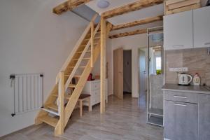 - une cuisine avec un escalier en bois dans une chambre dans l'établissement Apart Kobylí, à Kobylí
