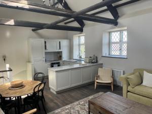 a kitchen with white cabinets and a table and chairs at Alms Houses in Kinsale