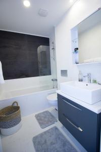 uma casa de banho com um lavatório, uma banheira e um WC. em 2 Rooms A504 StayInn by Cosmopolis em Ştefăneştii de Jos
