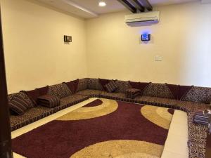 ein braunes Sofa in einem Zimmer mit einem Teppich in der Unterkunft ليلتنا1 in Ha'il