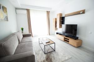 uma sala de estar com um sofá e uma televisão em 2 Rooms A504 StayInn by Cosmopolis em Ştefăneştii de Jos