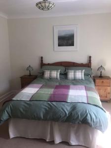 1 dormitorio con 1 cama con una manta colorida en No 96 Chapel Lane - Self Contained Cottage In The Heart Of Butleigh, en Butleigh