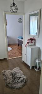 een woonkamer met een spiegel en een witte dressoir bij Maria`s place in Krivodol