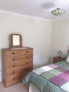 a bedroom with a dresser with a mirror on it at No 96 Chapel Lane - Self Contained Cottage In The Heart Of Butleigh in Butleigh