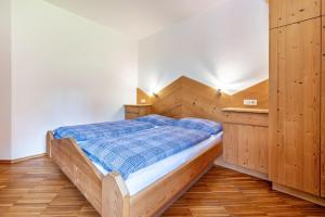 1 dormitorio con cama de madera en una habitación en Lindenhof Apt 9, en Vandoies