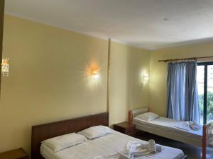 Habitación con 2 camas y ventana en Sanremo Hotel Restorant, en Durrës