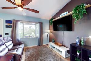 a living room with a couch and a flat screen tv at Sundial Sanctuary in Fort Myers