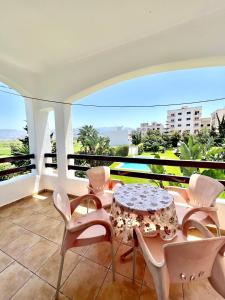 balcón con mesa, sillas y vistas en Relax Island, en Oued Laou