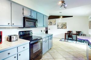 a kitchen with blue cabinets and a dining room at Sundial Sanctuary in Fort Myers