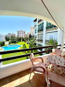 balcón con mesa y vistas a la piscina en Relax Island en Oued Laou