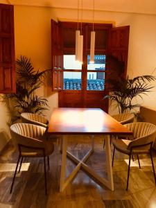una sala da pranzo con tavolo e sedie in legno di Fántastica vivienda en el pleno corazón de Granada a Granada