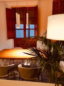una sala da pranzo con tavolo, sedie e una pianta di Fántastica vivienda en el pleno corazón de Granada a Granada