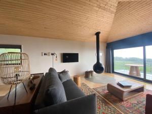 a living room with a couch and a large window at LUZZ me - Casa das Doze Ribeiras in Doze Ribeiras