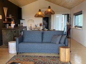 sala de estar con sofá azul y cocina en LUZZ me - Casa das Doze Ribeiras en Doze Ribeiras