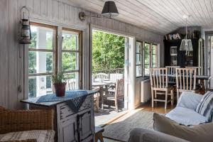 Fishermans cabin في Myttinge: مطبخ وغرفة معيشة مع طاولة وكراسي