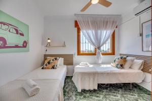 zwei Betten in einem weißen Zimmer mit Fenster in der Unterkunft VB Goya 7BR Andalusian Villa by the marina in Benalmádena + 36 Fotos