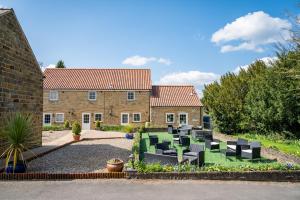 een huis met stoelen en tafels op een binnenplaats bij Finest Retreats - Bilsdale Hall Cottage in Thirsk