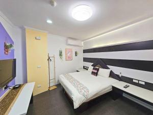 Habitación de hotel con cama y TV en 恆春古城親子民宿, en Hengchun