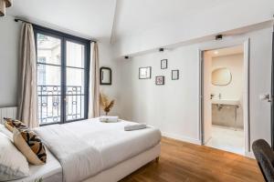 sypialnia z łóżkiem i dużym oknem w obiekcie Wonderful flat in the Marais neighbourhood - Paris - Welk w Paryżu