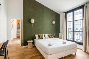 sypialnia z dużym łóżkiem i zieloną ścianą w obiekcie Wonderful flat in the Marais neighbourhood - Paris - Welk w Paryżu