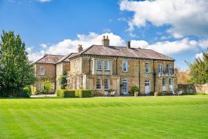 a large brick house with a large green lawn at Finest Retreats - Hambleton Hall Apt in Thirsk