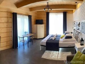 1 dormitorio con 1 cama grande y 1 mesa en SASÓWKA APARTAMENT en Maniowy