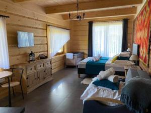 1 dormitorio con 2 camas, mesa y sillas en SASÓWKA APARTAMENT en Maniowy