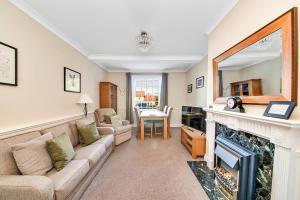 a living room with a couch and a fireplace at Finest Retreats - Kilburn Hall Apt in Thirsk