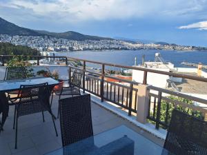 a balcony with a table and chairs and a view of the water at Kouros Studios in Kavála