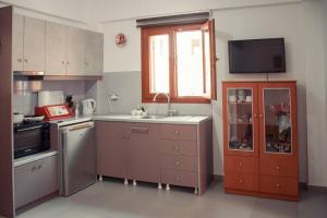 cocina con fregadero, fogones y ventana en Seagull House, en Ayía Kiriakí