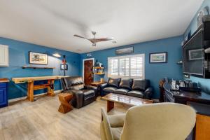 una sala de estar con paredes azules y muebles de cuero. en Desert Haven Hideaway, en Phoenix