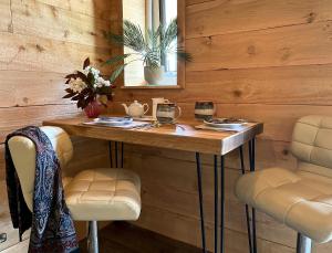 a room with a wooden wall with a table and two chairs at TVF Stable Suites in Nether Stowey