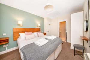 a bedroom with a large bed with two towels at Finest Retreats - Ryedale Hall Cottage in Thirsk +5 photos