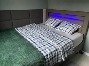 uma cama com lençóis e almofadas xadrez em Leśna Polana Domki em Okuninka
