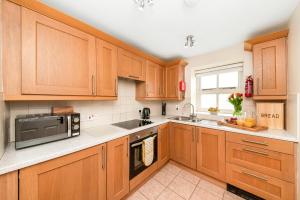 a kitchen with wooden cabinets and a microwave at Finest Retreats - Swaledale Hall Cottage in Thirsk