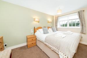 ein Schlafzimmer mit einem Bett und einem Fenster in der Unterkunft Finest Retreats - Swaledale Hall Cottage in Thirsk