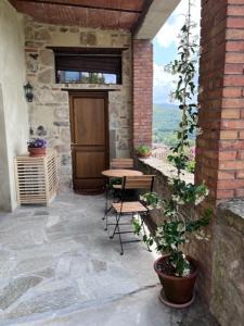 une terrasse avec une porte, une table et une plante dans l'établissement Cantina nel Castello, à Montegiovi