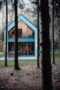 niebieski dom w środku lasu w obiekcie Apartamenty Leśne Historie 1 w mieście Gołuchów