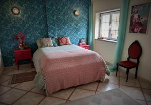托馬爾的住宿－Casa Azul Tomar privé vakantiehuis，卧室配有床、椅子和窗户。