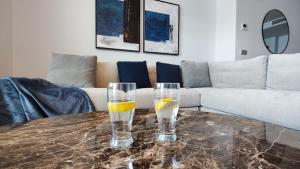 een tafel met twee glazen water en sinaasappels erop bij SUNSET CLIFFS modern apartment in Benidorm
