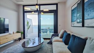 ein Wohnzimmer mit einem Sofa und einem Glastisch in der Unterkunft SUNSET CLIFFS modern apartment in Benidorm