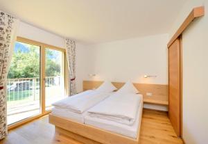 a bedroom with a bed and a large window at Landhaus Valfontana in Vandans