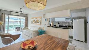 a kitchen and living room with a table and a couch at Alugar na Riviera Hotel Ilha da Madeira Resort in Riviera de São Lourenço